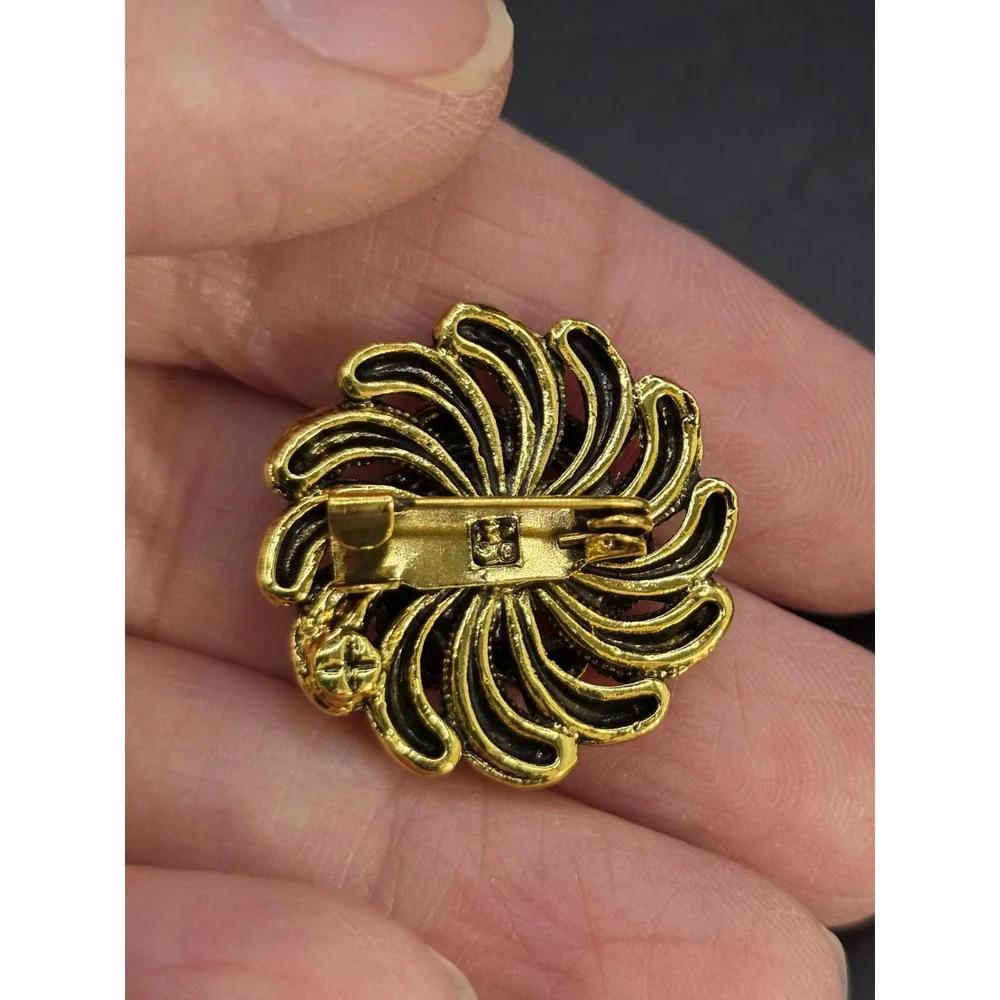 gold-toned vintage style flower brooch with blue and iridescent rhinestones